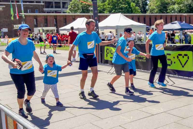 Zwei Familien mit Ihren Kindern Hand in Hand am Start